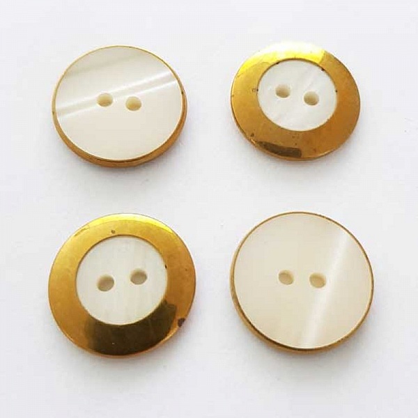Quatre boutons ronds dorés et nacrés de 20 mm.