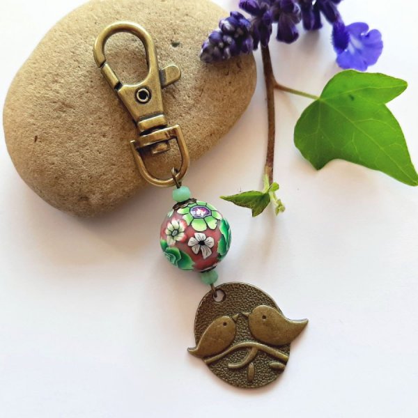 medaglia portachiavi duo di uccelli color bronzo e perla con motivo floreale verde e vino multicolore
