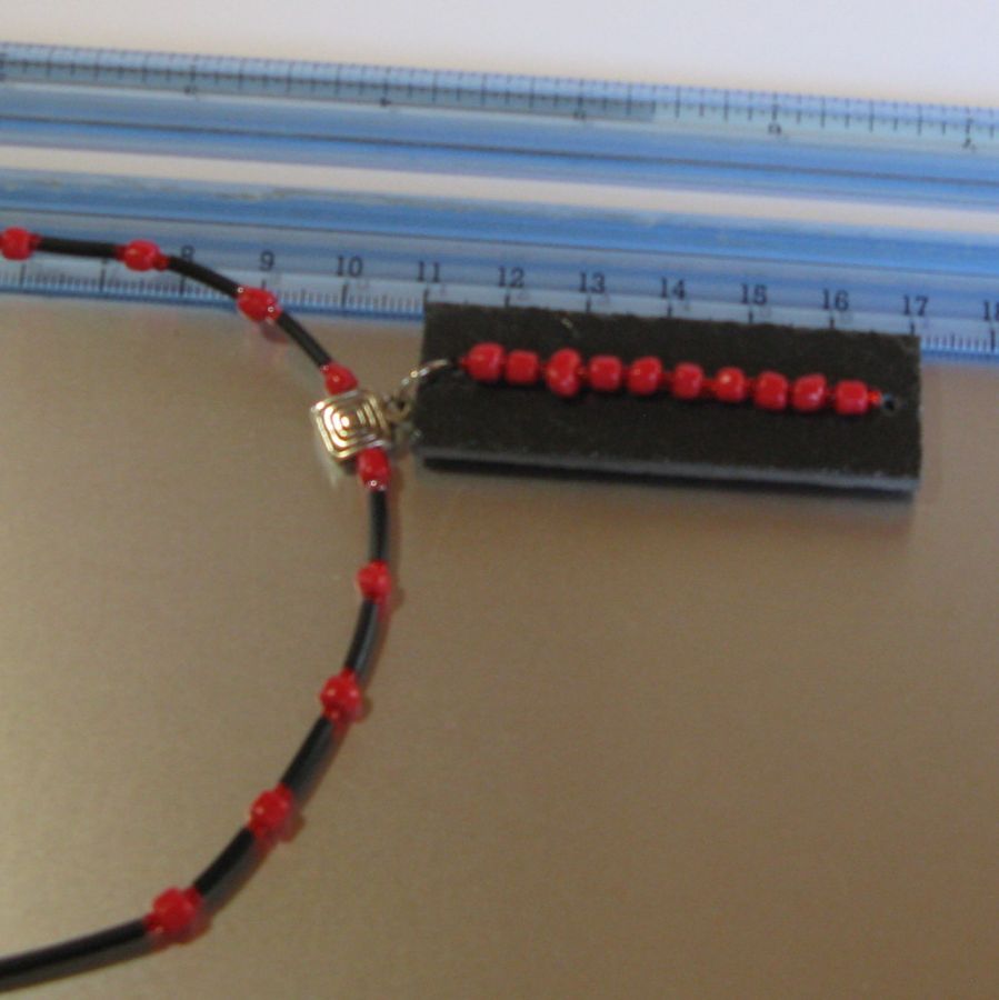 Collana da donna in ardesia e perle rosse montate su un cordoncino di silicone nero, creazione unica