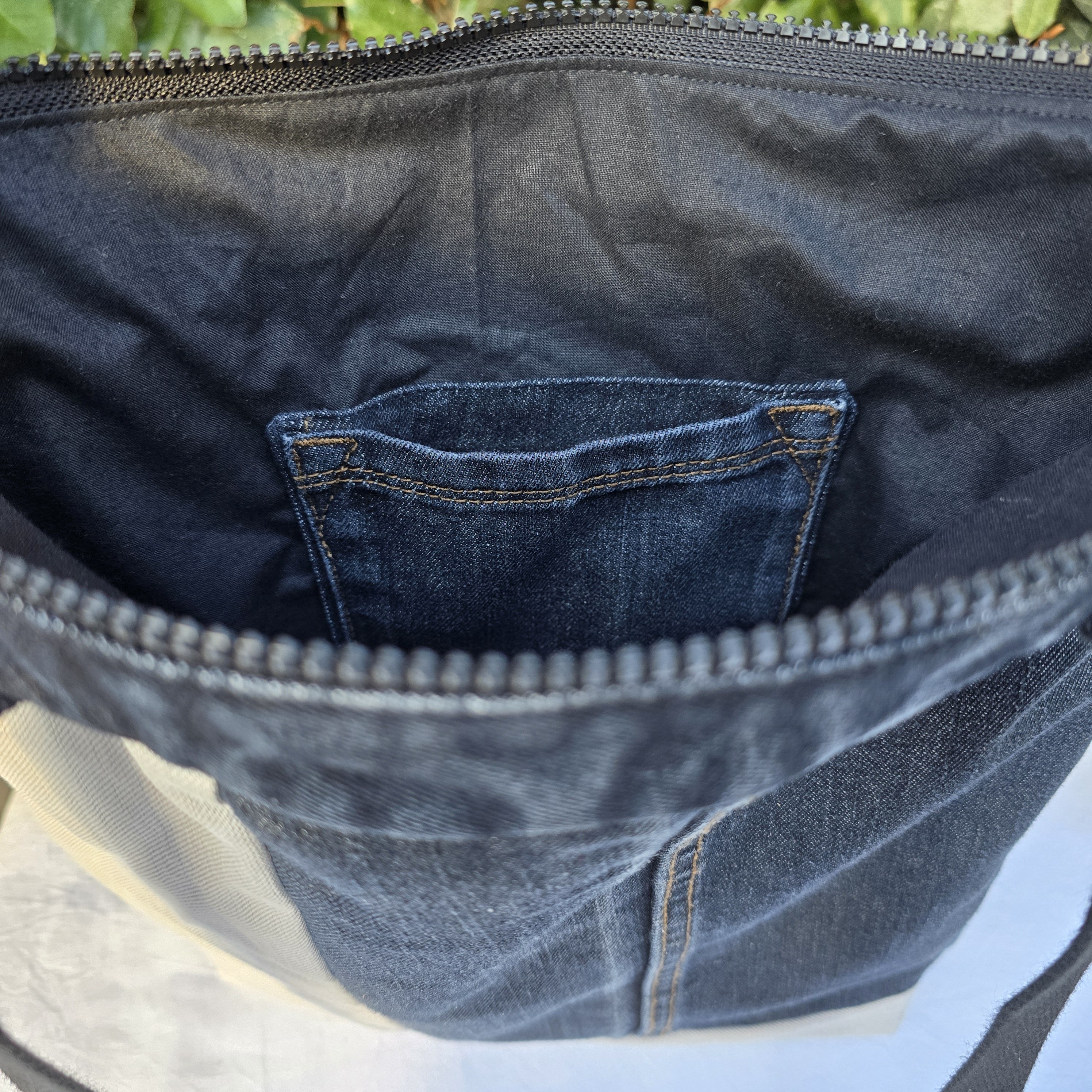 Sac &agrave; bandouli&egrave;re en jean recycl&eacute; noir et gris avec empi&egrave;cements.