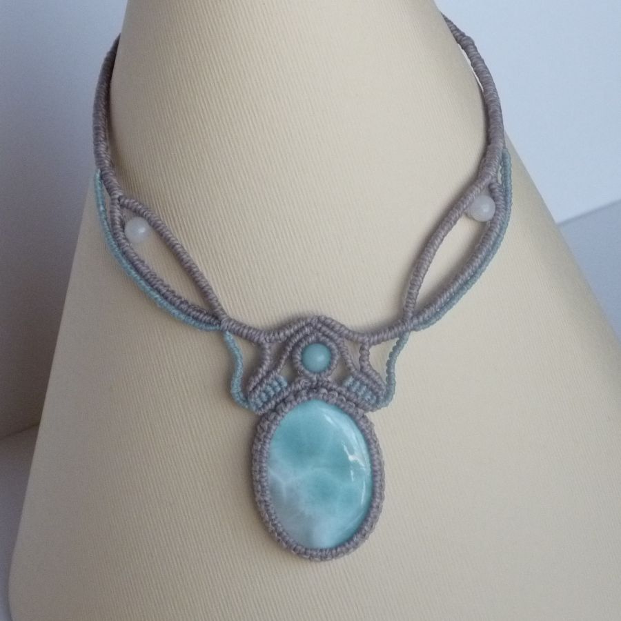 Collana in micro-macramè grigio tortora/blu smerigliato con al centro una gemma naturale nei toni tenui del bianco e dell'azzurro.