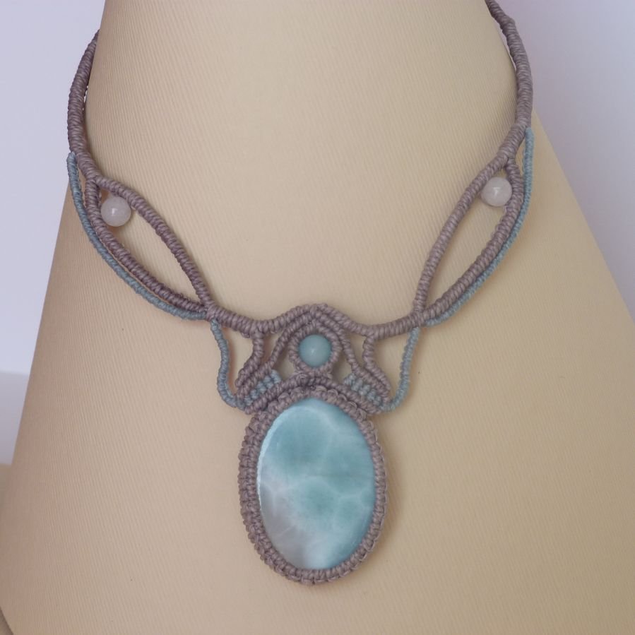 Collana in micro-macramè grigio tortora/blu smerigliato con al centro una gemma naturale nei toni tenui del bianco e dell'azzurro.