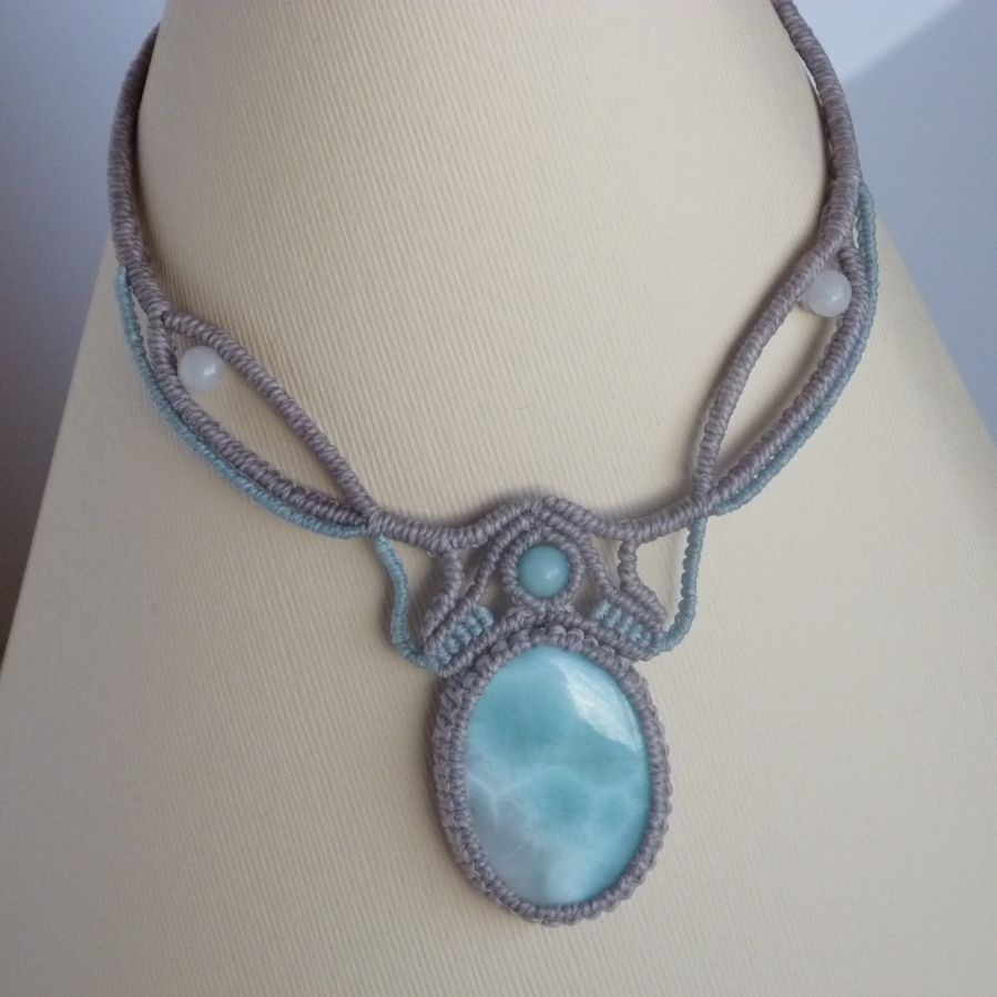 Collana in micro-macramè grigio tortora/blu smerigliato con al centro una gemma naturale nei toni tenui del bianco e dell'azzurro.