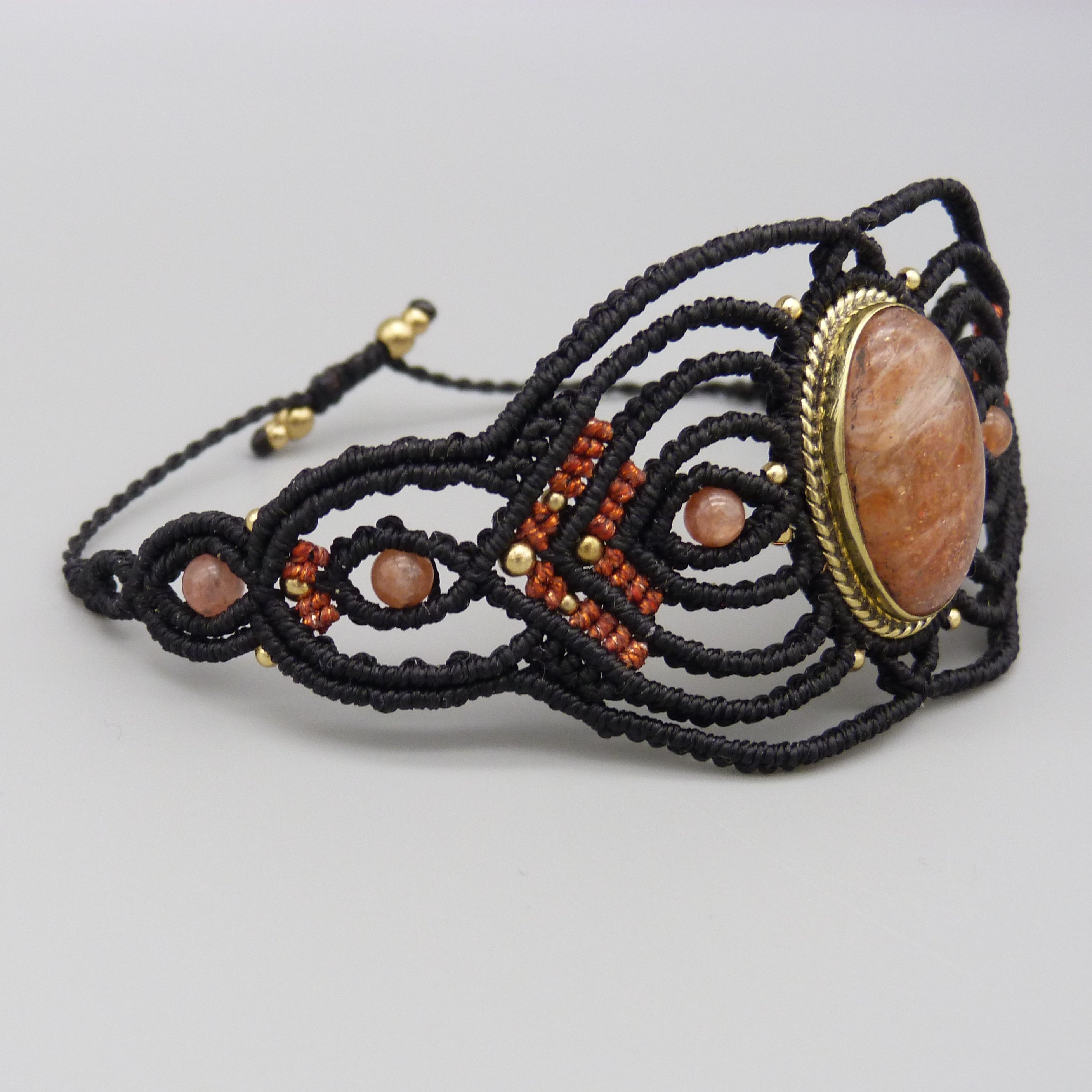 Manchette noire en micro-macramé avec une pierre de soleil
