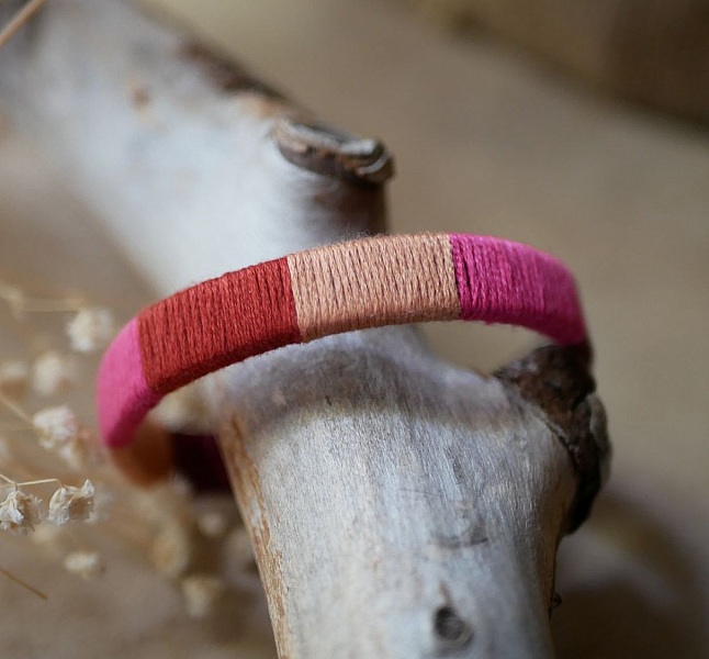 Bracelet en cuir fuchsia style boh&egrave;me tiss&eacute; de fils de coton tons p&ecirc;ches et roses