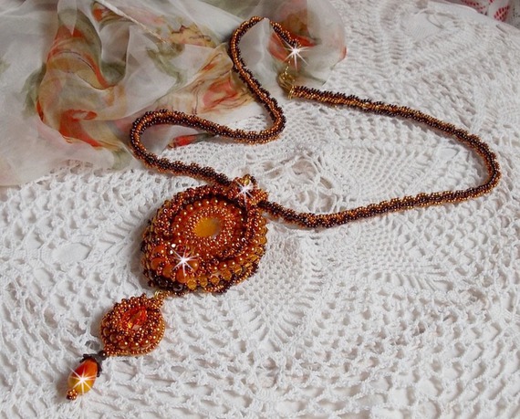 La collana con ciondolo Lady in Orange è ricamata con cristalli Swarovski, perline Miyuki e perline magiche.