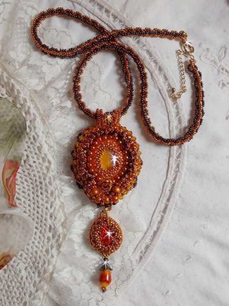 La collana con ciondolo Lady in Orange è ricamata con cristalli Swarovski, perline Miyuki e perline magiche.