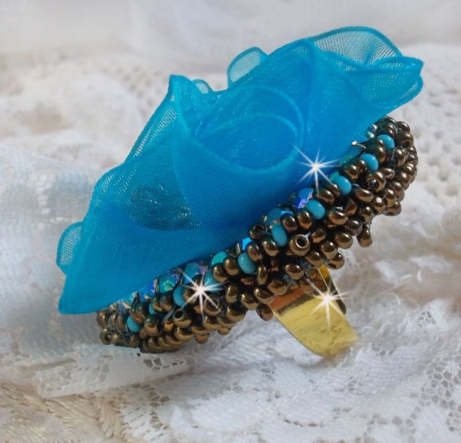 Ilycia Incantevole anello ricamato con un cabochon di resina blu turchese sfaccettato e un nastro di organza