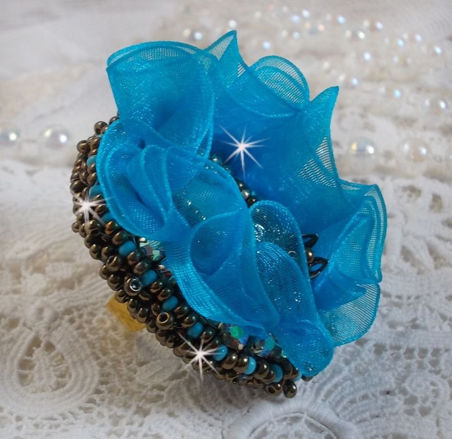 Ilycia Incantevole anello ricamato con un cabochon di resina blu turchese sfaccettato e un nastro di organza