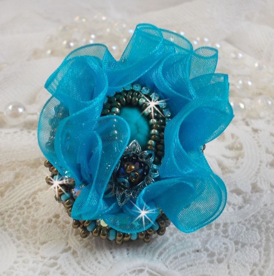 Ilycia Incantevole anello ricamato con un cabochon di resina blu turchese sfaccettato e un nastro di organza