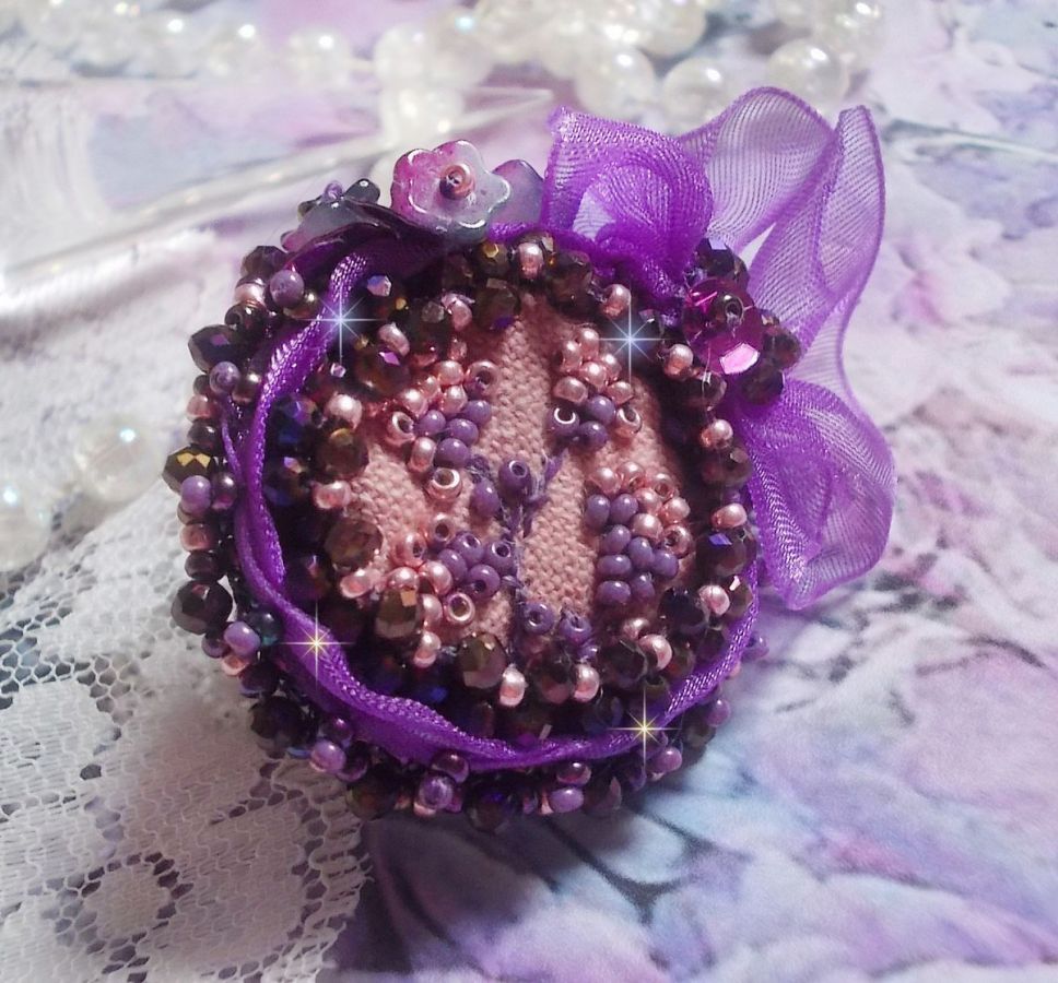 Anello romantico per signora ricamato su un tessuto di lino rosa con perline rosa, iris, viola e pesca 