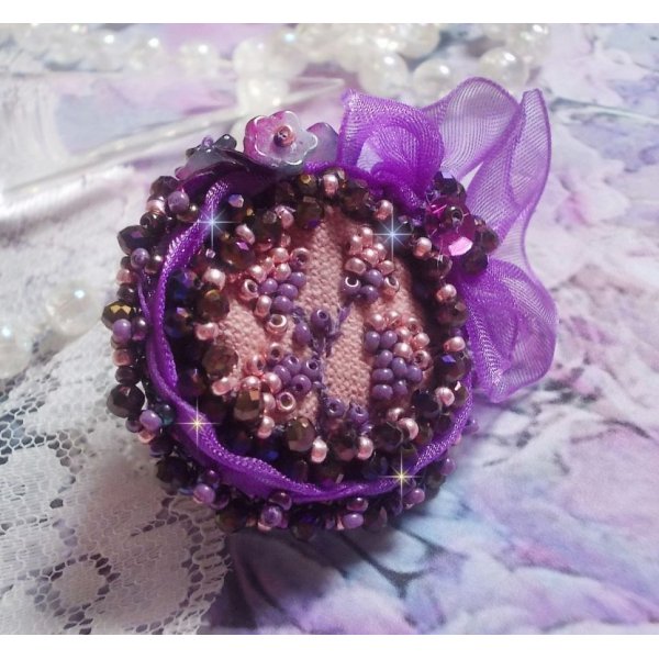 Anello romantico per signora ricamato su un tessuto di lino rosa con perline rosa, iris, viola e pesca 