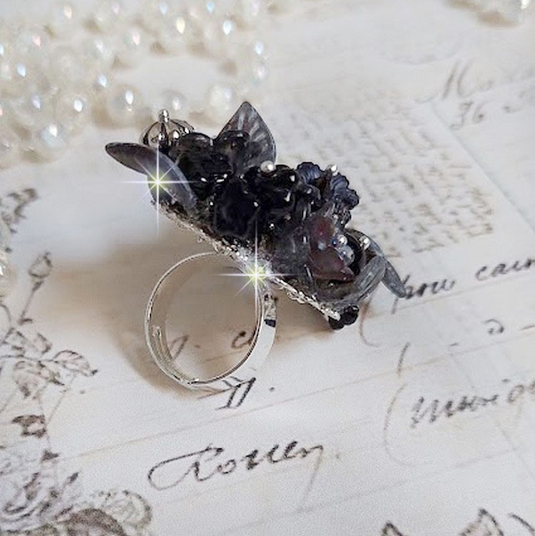 Bague Soir de Lune créée avec des fleurs lucites Noires et Grises peintes à la main, cristaux, perles en résine, perles en verre et coupelle argentée. Le tout est monté sur une bague argentée