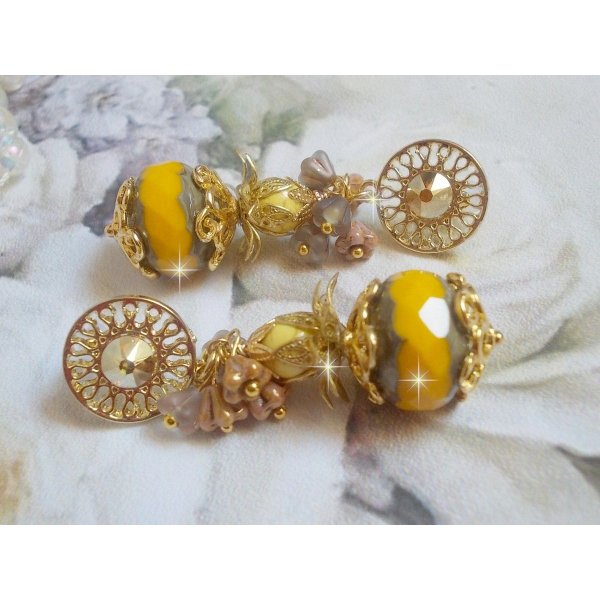 BO Lumi&egrave;re Opale Jaune avec des perles potirons jaunes &agrave; laquelle s&rsquo;ajoute des fleurs, cabochons en cristal, coupelles et perles rondes. Mont&eacute;s sur clous d&rsquo;oreilles en M&eacute;tal. Un style moderne