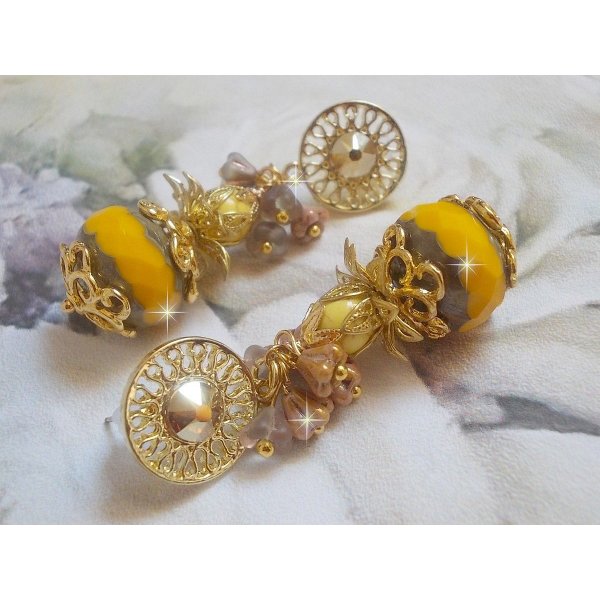 BO Lumi&egrave;re Opale Jaune avec des perles potirons jaunes &agrave; laquelle s&rsquo;ajoute des fleurs, cabochons en cristal, coupelles et perles rondes. Mont&eacute;s sur clous d&rsquo;oreilles en M&eacute;tal. Un style moderne