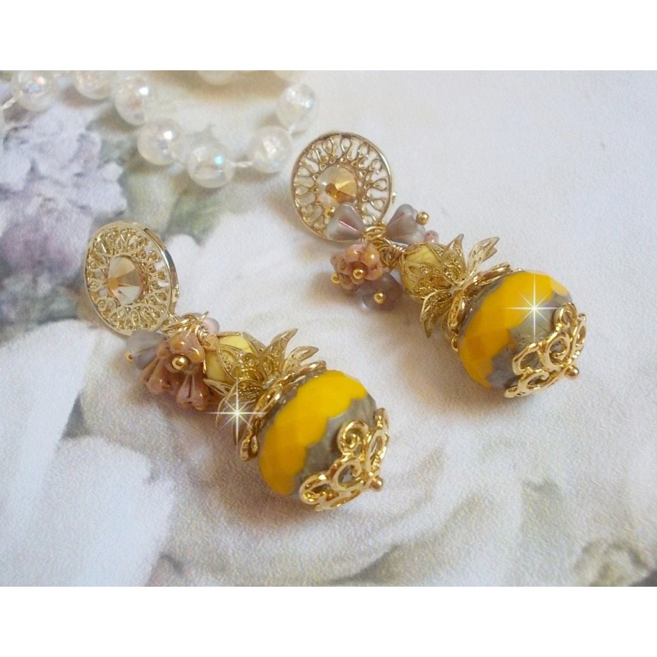 BO Lumière Opale Jaune avec des perles potirons jaunes à laquelle s’ajoute des fleurs, cabochons en cristal, coupelles et perles rondes. Montés sur clous d’oreilles en Métal. Un style moderne