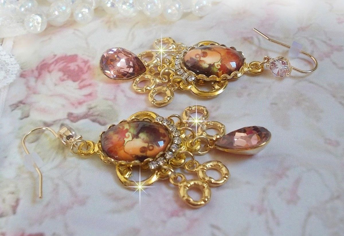 BO Paris représentant une jeune femme à Paris, orné d’une chaîne strass Cristal/Doré avec des breloques, des pendants ovales Blush Rose, montés sur des crochets en plaqué Or. Paris en mode vintage.