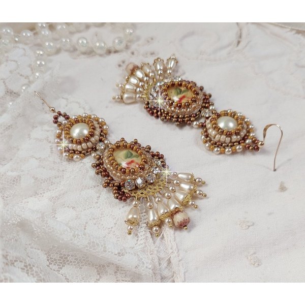 I BO Reflets de Ros&eacute;e sono ricamati con perle perlate, cristalli Swarovski e ganci per orecchie in oro 14 carati.