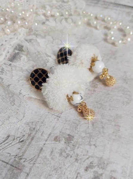 BO Cassandre avec des pierres de gemme : le Howlite Blanc &agrave; laquelle s&rsquo;ajoute des pompons, des intercalaires rondelles, des coupelles feuilles et breloques. Mont&eacute;s sur des puces Noires et Dor&eacute;es 