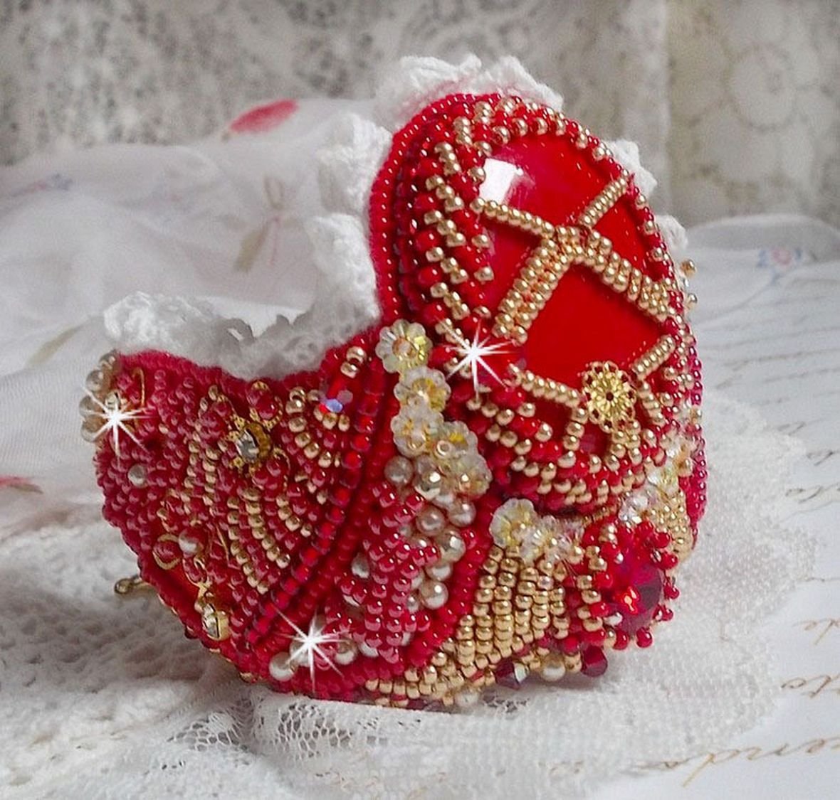 Bracciale Nous Two Haute-Couture ricamato con cristalli Swarovski, un cabochon ovale in vetro rosso e perle di semi