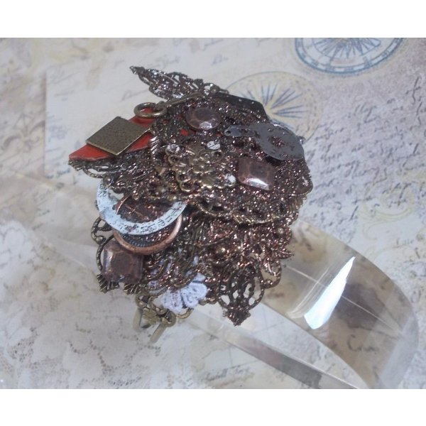 Bracciale Navigating Shadow creato con pelle color cognac, fiore in tessuto, accessori in bronzo, rame e nero con ciondoli.