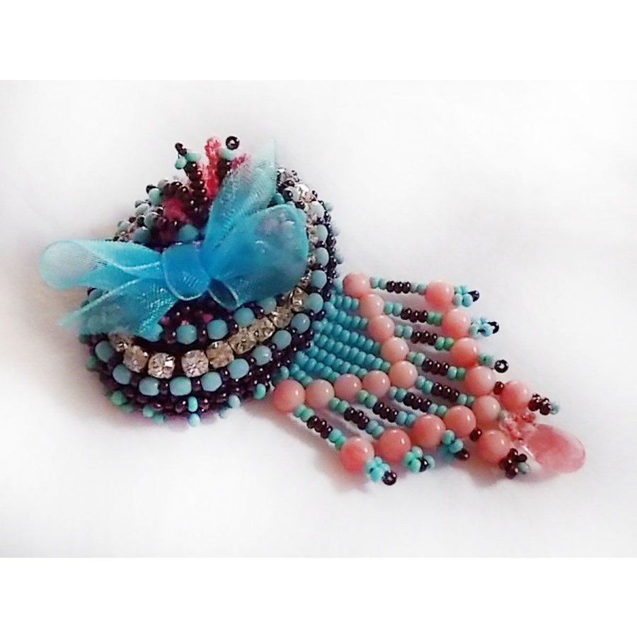 Spilla a forma di naiade ricamata con perle di pietra (turchese e corallo), cristalli, pelle di vacchetta e perle di seme