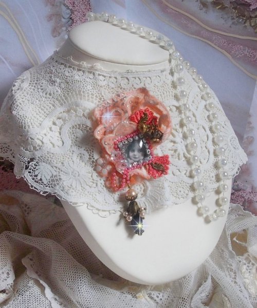 Spilla a forma di rosa rustica creata con un cabochon raffigurante una ragazza sorridente, strass arancione e pizzo rosa, cristalli, perline di vetro e accessori vari.