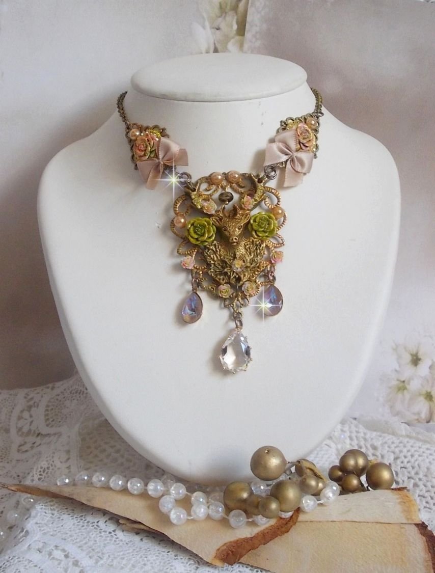 Collier Cerf Fleuri crée avec des cristaux de Swarovski, cabochons en résine, perles en verre, tête de cerf avec bois en métal, pendentif larme en zircon, nœuds en satin et accessoires en laiton 