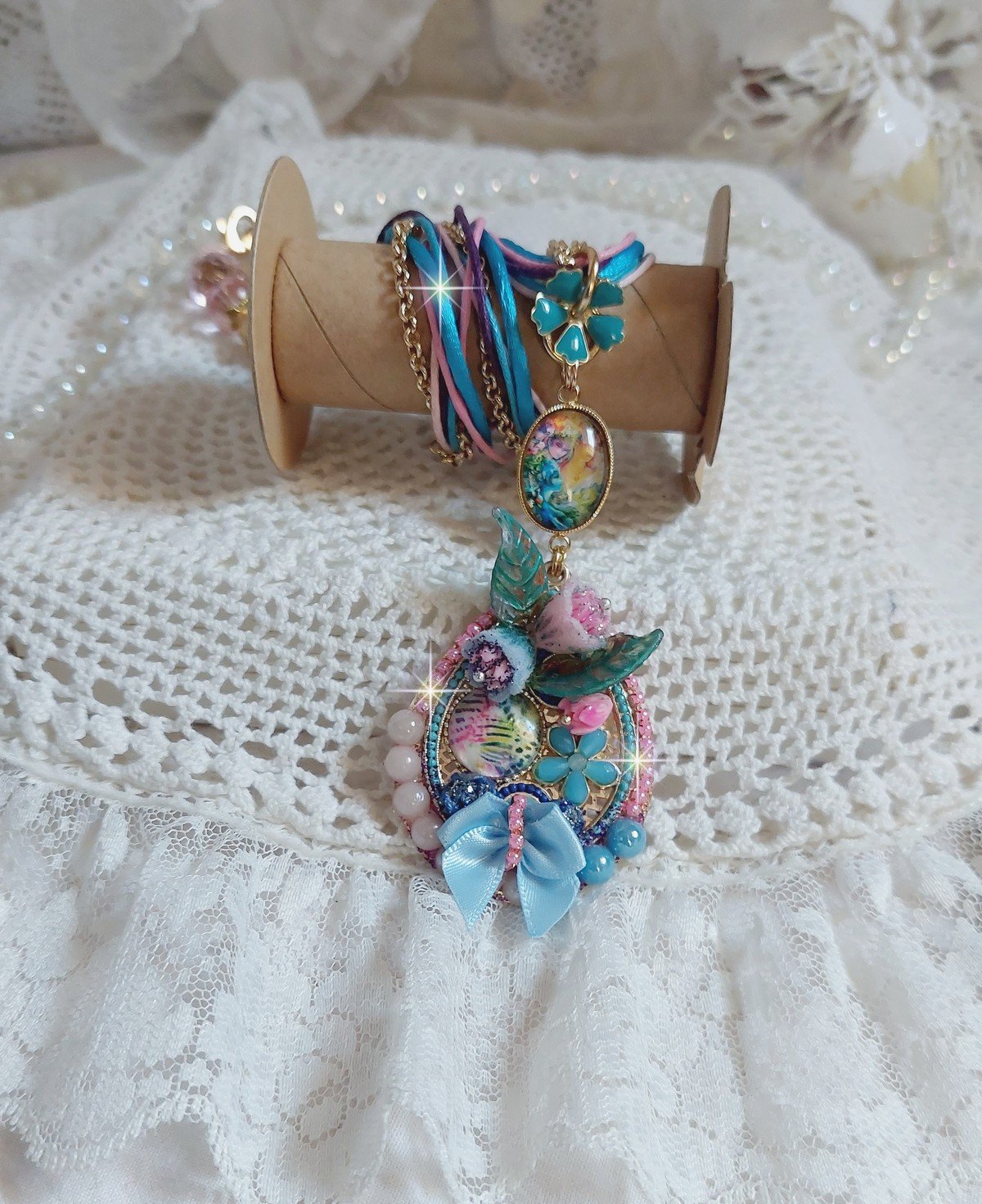  Collier Coquette créé avec deux estampes à laquelle s’ajoute des fleurs en velours floqué, perles aplaties Cristal, fleurs : Epoxy, Porcelaine, Résine, cabochon loupe, rubans et chaîne plaqué Or