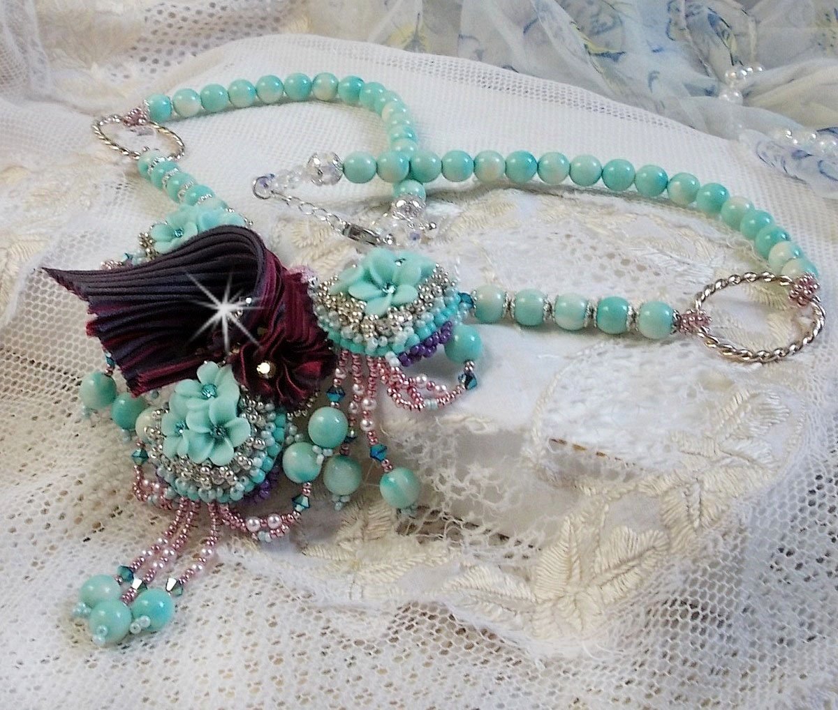 Collana Blue Flowers Haute-Couture ricamata con cristalli Swarovski, nastro di seta tartufo/raspberry e perle di semi