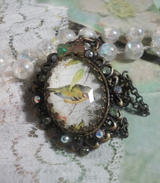 Collana Garden Bird creata con cabochon di bava e cristalli montati su accessori in bronzo