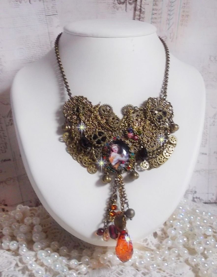 La collana Mes Passions Broc crea una donna dai capelli dorati con fiori, accessori in bronzo, ciondoli in cristalli e una catena di strass.