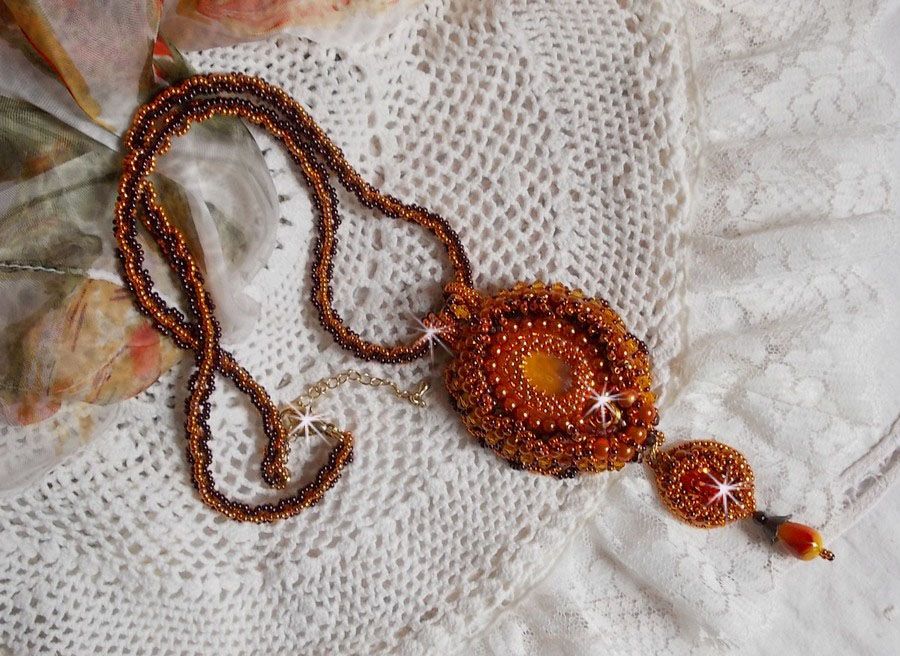 La collana con ciondolo Lady in Orange è ricamata con cristalli Swarovski, perline Miyuki e perline magiche.