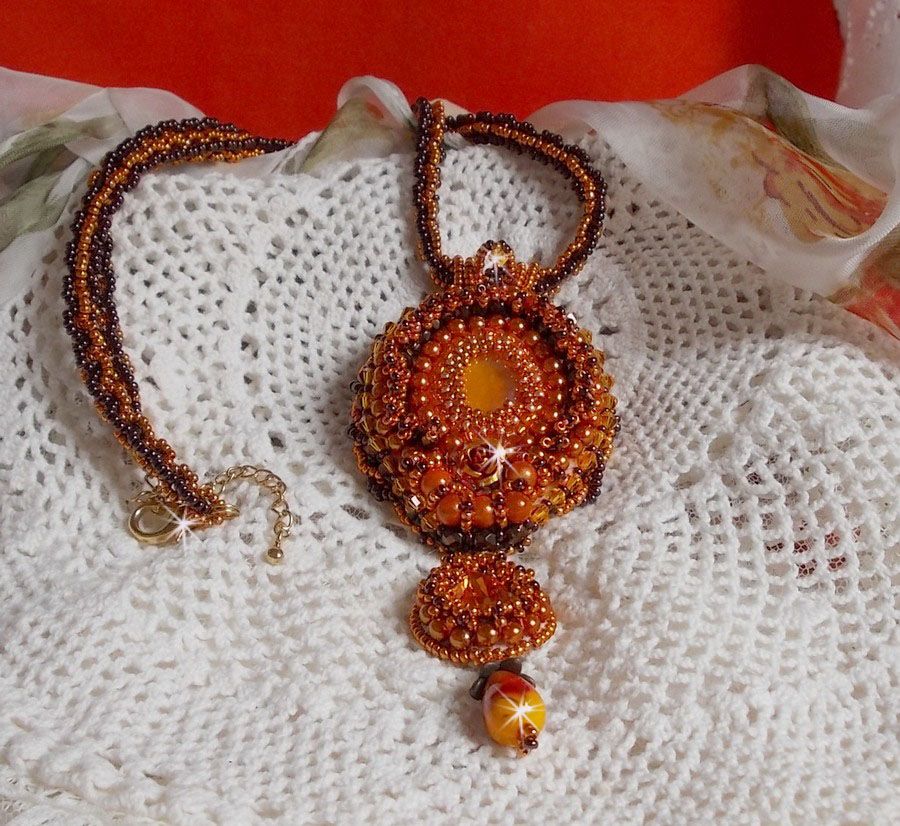 La collana con ciondolo Lady in Orange è ricamata con cristalli Swarovski, perline Miyuki e perline magiche.