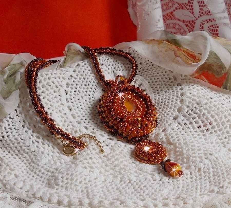 La collana con ciondolo Lady in Orange è ricamata con cristalli Swarovski, perline Miyuki e perline magiche.