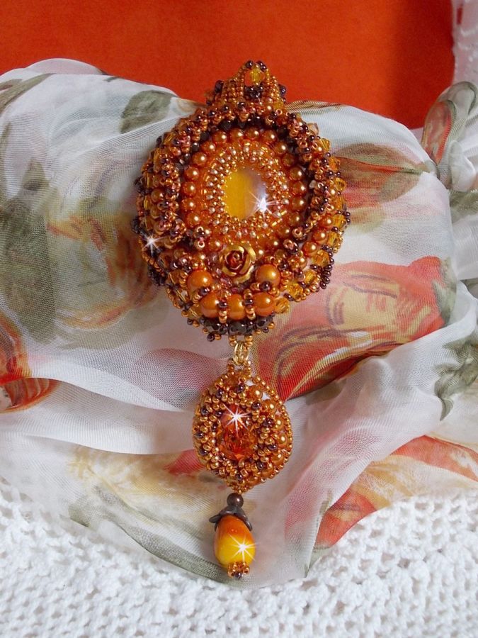 La collana con ciondolo Lady in Orange è ricamata con cristalli Swarovski, perline Miyuki e perline magiche.