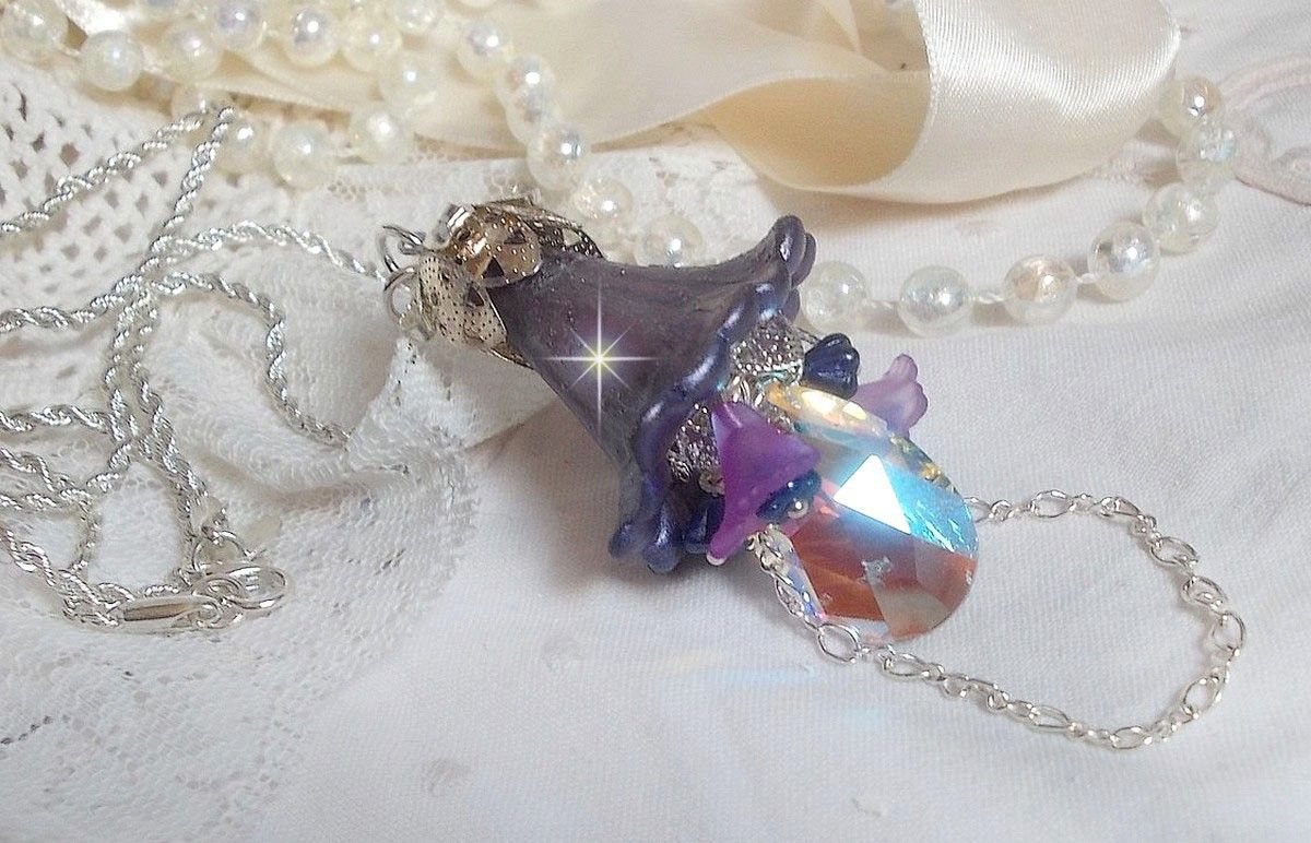 Pendentif Eclat de Cristal monté avec une goutte en Cristal, fleurs en Verre, fleurs lucites dont une plus grande peinte à la main avec paillettes Argentées. Une composition florale