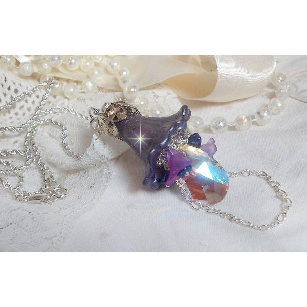 Pendentif Eclat de Cristal monté avec une goutte en Cristal, fleurs en Verre, fleurs lucites dont une plus grande peinte à la main avec paillettes Argentées. Une composition florale