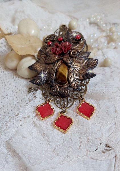 Pendentif M&eacute;lodie avec un cabochon &OElig;il de tigre orn&eacute; de perles en Jade Rouge vein&eacute; de Noir sur fleurs 5 p&eacute;tales et estampes mont&eacute;s sur une cha&icirc;ne bronze. Les pendants sont en r&eacute;sine &eacute;poxy Rouge