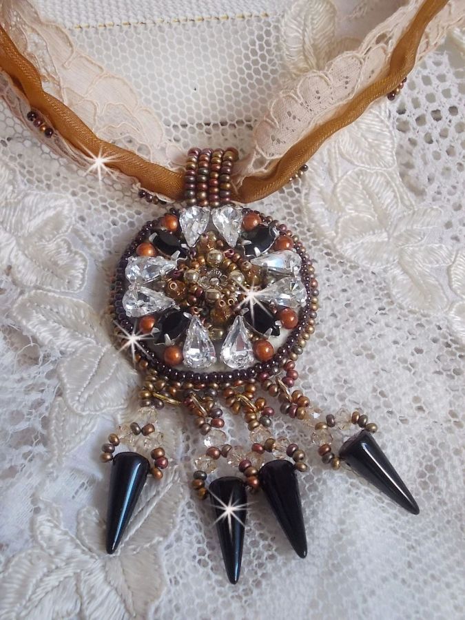 Pendentif Pampilles Amber brodé avec des Cristaux de Swarovski, des facettes Antique, des spikes noires, une estampe dorée filigranée, des rocailles et de la dentelle ancienne