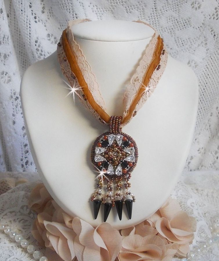 Pendentif Pampilles Amber brodé avec des Cristaux de Swarovski, des facettes Antique, des spikes noires, une estampe dorée filigranée, des rocailles et de la dentelle ancienne