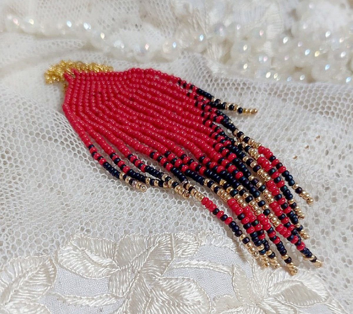 Ciondolo a volute rosse creato con perline di qualità e catena placcata in oro