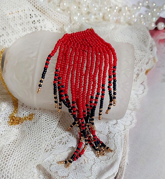 Ciondolo a volute rosse creato con perline di qualit&agrave; e catena placcata in oro