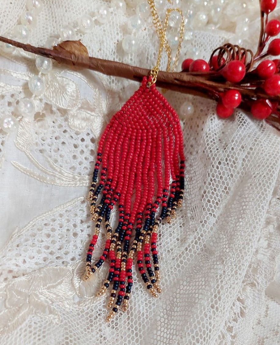 Ciondolo a volute rosse creato con perline di qualità e catena placcata in oro