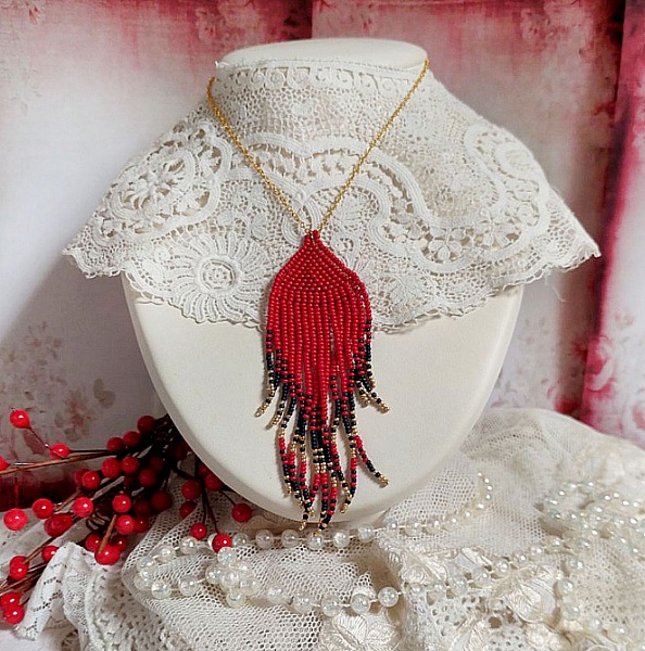 Ciondolo a volute rosse creato con perline di qualit&agrave; e catena placcata in oro