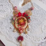 Collier Roseraie Provençale crée avec des perles en verre, céramique, résine, des accessoires en plaqué Or et autres avec un nœud en satin Rouge