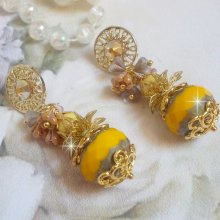 BO Lumière Opale Jaune avec des perles potirons jaunes à laquelle s’ajoute des fleurs, cabochons en cristal, coupelles et perles rondes. Montés sur clous d’oreilles en Métal. Un style moderne